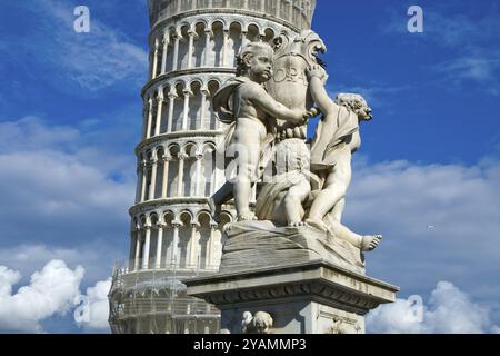 Statua del cherubino che si trova sul campo dei Miracoli a Pisa con la torre pendente sullo sfondo Foto Stock