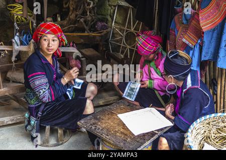 SAPA, VIETNAM, 16 NOVEMBRE: Le donne vietnamite del gruppo etnico di minoranza Hmong in abito nazionale stanno realizzando souvenir fatti a mano il 16 novembre 2016 in Foto Stock