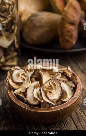Funghi porcini secchi. Bolo tagliato a fette in un recipiente di legno su un tavolo di legno. Foto Stock