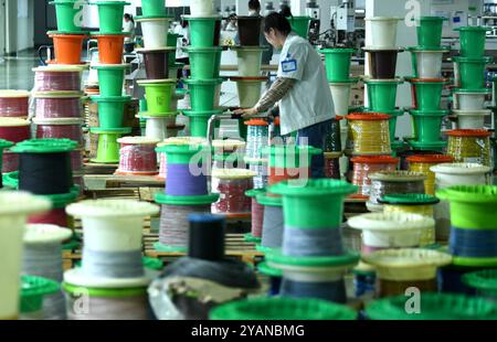 HAIAN, CINA - 15 OTTOBRE 2024 - i lavoratori producono parti di veicoli commerciali di nuova energia presso un'officina di Haian, provincia di Jiangsu, Cina, 15 ottobre 2024. Foto Stock