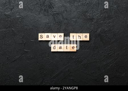 Salvare la data scritta sul blocco di legno. Salvare la data del testo in tabella, concetto. Foto Stock