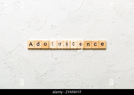 parola adolescenza scritta su blocco di legno. testo adolescente sulla tabella, concetto. Foto Stock