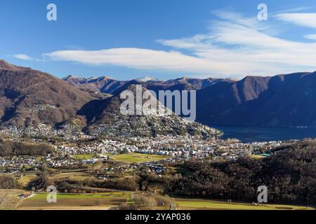 Svizzera: La città di Lugano e le montagne intorno al lago di Lugano, prese da Cadamario Foto Stock