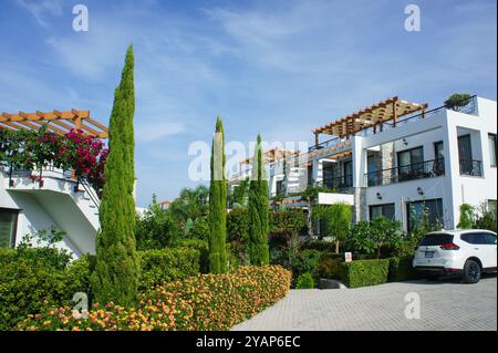 Immerso nel verde lussureggiante, un moderno rifugio giardino vanta un'architettura unica, piante fiorite e un paesaggio vivace che crea un tranquillo bancomat Foto Stock