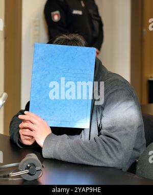 Amburgo, Germania. 15 ottobre 2024. Un uomo di 34 anni accusato di omicidio e di incendio doloso particolarmente grave sta aspettando in aula l'inizio del processo. Si dice che l'accusato abbia pugnalato la vittima diverse volte nella zona testa e collo con un coltello. L'attacco ha portato alla morte dell'uomo. L'accusato ha poi presumibilmente dato fuoco all'appartamento per coprire il crimine. Crediti: Ulrich Perrey/dpa/Alamy Live News Foto Stock