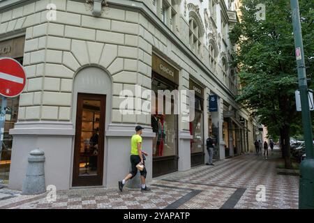 Praga, Repubblica Ceca, Man Walking, Front, Gucci Shop, via dello shopping di lusso, nel centro storico di Pařížská Foto Stock