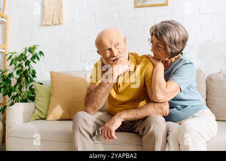 Una moglie premurosa offre conforto a suo marito mentre condividono un momento intimo a casa. Foto Stock
