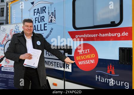 Amburgo, Germania. 15 ottobre 2024. Andreas Dressel (SPD), senatore delle Finanze di Amburgo, lancia la campagna d'informazione sulle tasse immobiliari "Fiera per tutti" di fronte a un info mobile presso Gänsemarkt. Nei prossimi mesi, un team di dipendenti delle autorità fiscali visiterà vari uffici fiscali per informare i residenti di Amburgo della nuova tassa immobiliare. Crediti: Ulrich Perrey/dpa/Alamy Live News Foto Stock