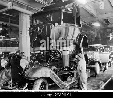 La storia della Ford. Lo stabilimento di Highland Park, Michigan, USA, era uno stabilimento di produzione per la Model T ed è diventato famoso per essere stato il primo stabilimento nella storia a assemblare auto su una catena di montaggio in movimento. Nel 1927 il nuovo modello A era in produzione e la foto scattata quell'anno mostra la linea di assemblaggio con carrozzerie e telai assemblati dai lavoratori di fabbrica. Foto Stock