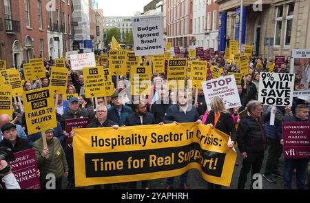 Persone del settore alberghiero e del commercio al dettaglio protestano fuori Leinster House, Dublino, per evidenziare gli alti costi che le piccole e medie imprese devono sostenere. Data foto: Martedì 15 ottobre 2024. Foto Stock