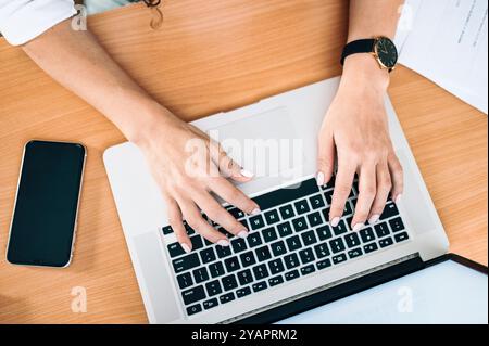 Primo piano di una donna caucasica bianca che scrive su un computer portatile su una scrivania, concetto di telelavoro da casa (di Ivan Radic) Foto Stock