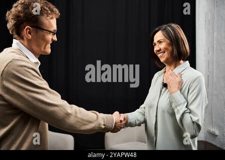 Un giornalista coinvolge uno specialista in un colloquio approfondito, condividendo approfondimenti e competenze in un accogliente studio. Foto Stock