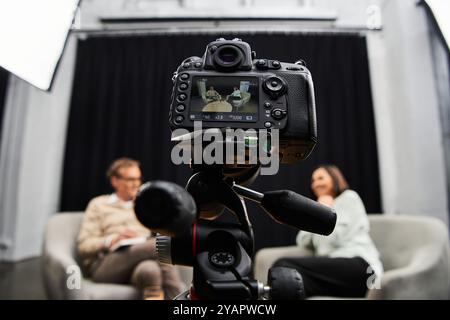 In uno studio moderno, una giornalista intervista attentamente una donna esperta, favorendo un dialogo approfondito. Foto Stock