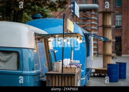 Furgone hot dog e caffè da asporto per strada cittadina, furgone mobile di cibo. Caffè in pulmino con menu all'aperto Foto Stock