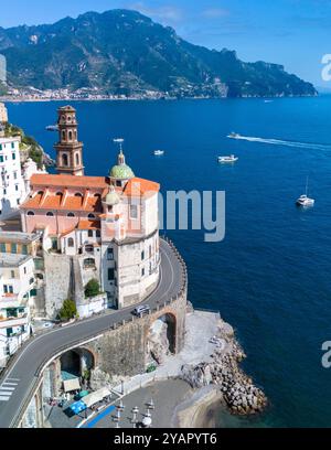 Scopri la splendida Costiera Amalfitana, dove edifici colorati si arrampicano sulle scogliere, affacciati sulle acque blu profonde. Le barche scorrono dolcemente attraverso le onde Foto Stock