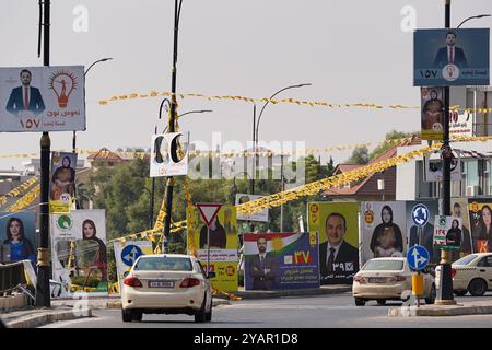 Duhok, Iraq. 13 ottobre 2024. Un'auto ha visto passare le bandiere elettorali per i candidati in vista delle elezioni del Parlamento regionale del Kurdistan nella città di Duhok, Iraq. (Foto di Ismael Adnan/SOPA Images/Sipa USA) credito: SIPA USA/Alamy Live News Foto Stock