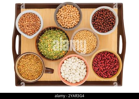 Varietà di prodotti proteici per vegetariani. Soia, lenticchie, piselli, ceci e vari tipi di fagioli in ciotole su un vassoio Isolato su un backgrou bianco Foto Stock