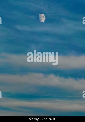 High in the Sky: Moon Phase as Earth's satellite with Clouds as Leading Lines, Top of the World Concept Foto Stock