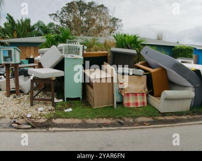 Grandi mucchi di spazzatura, mobili, oggetti per la casa impilati sul lato di un marciapiede in mattoni. Dopo una tempesta che danneggia un'inondazione causata da una tempesta d'acqua. Foto Stock