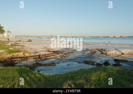 La spiaggia ha danneggiato l'onda della tempesta dopo gli uragani Helene e Milton a Gulfport Beach in Florida. Solchi, calanchi, canali d'acqua e detriti nella sabbia in ritardo Foto Stock