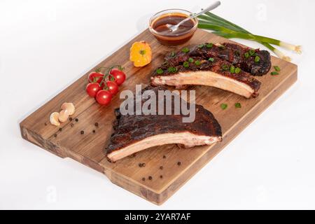 Deliziose costolette di maiale affumicate con verdure fresche e vivaci che stuzzicano le papille gustative Foto Stock