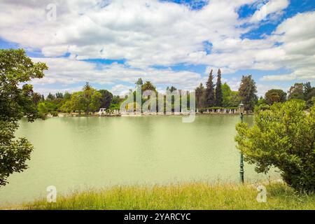 I visitatori apprezzano l'atmosfera serena del lago nel Parque General San Martin, circondato da alberi vibranti, perfetto per rilassarsi e divertirsi Foto Stock