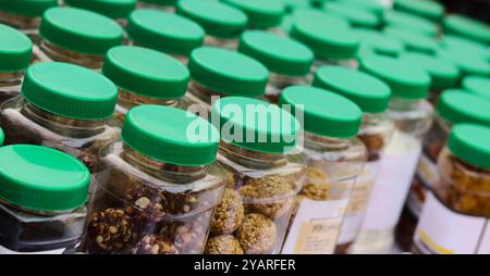 Vasetti da snack assortiti con coperchi verdi in fila Foto Stock