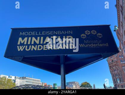 Symbolbild Schild des Miniatur Wunderlandes Hamburg, schwarzer Hintergrund mit goldener Schrift, Hinweis auf die größte Modelleisenbahnanlage der Welt, klarer Bezug zur Attraktion, ikonische Lage in der Speicherstadt Hamburg, modernes Design, Logos mit Symbolen für verschiedene Themenwelten Flugzeuge für für Präzision Foto Stock