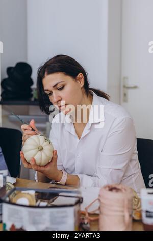 Bambini e adulti dipingono le zucche per Halloween, divertendosi e divertendosi insieme. Foto di alta qualità Foto Stock