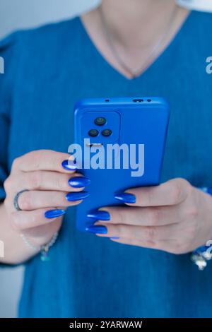 Le mani di una donna con uno smartphone di grandi dimensioni Foto Stock