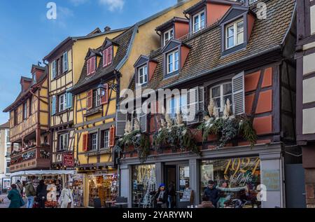 Las calles de Colmar en Navidad con sus pintorescas casas de entramado de madera decoradas con guirnaldas, luces y adornos tradicionales. Francia Foto Stock