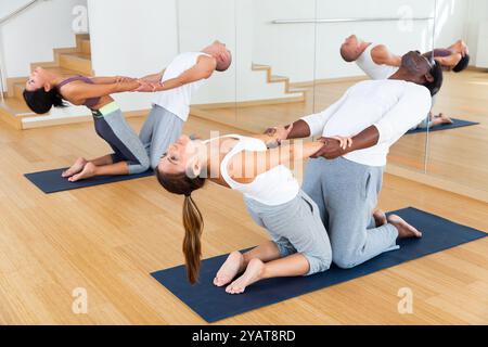 Lezioni di yoga per coppie nel moderno centro fitness Foto Stock