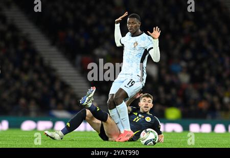 Glasgow, Regno Unito. 15 ottobre 2024. Ryan Christie di Scozia e Nuno Mendes del Portogallo durante la partita di UEFA Nations League a Hampden Park, Glasgow. Il credito per immagini dovrebbe essere: Neil Hanna/Sportimage Credit: Sportimage Ltd/Alamy Live News Foto Stock