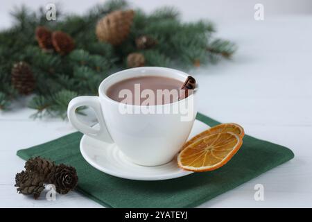 Ottimo cacao in tazza e rami di abete su un tavolo di legno bianco Foto Stock