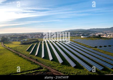 Vista aerea dei pannelli solari installati sul paesaggio agricolo contro il cielo blu. Il terreno agricolo è completamente attrezzato con generatori di energia rinnovabile verde. Foto Stock