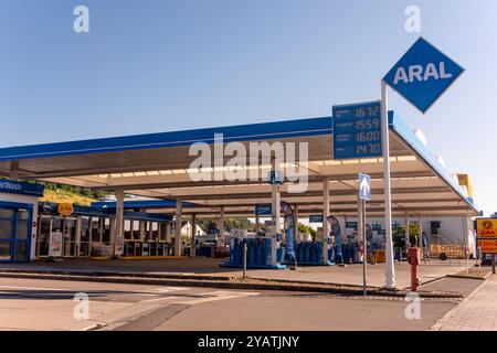 Wasserbillig, Lussemburgo - 29 luglio 2024: Una stazione di servizio ARAL ben illuminata dispone di diverse pompe di rifornimento sotto un cielo azzurro, che mostrano il carburante attuale p Foto Stock