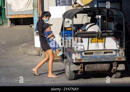 SAMUT PRAKAN, THAILANDIA, 08 febbraio 2023, Una donna con un bambino entra in un taxi a tre ruote Tuk Tuk motorizzato Foto Stock