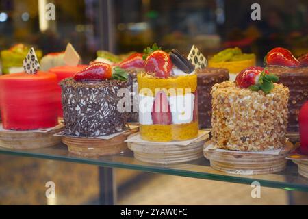 Un delizioso assortimento di mini torte esposto oggi stesso in una cassa da forno Foto Stock