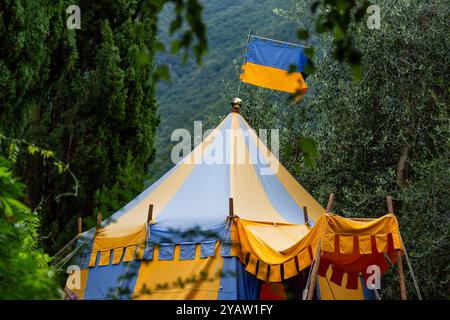 Tenda da da circo in stile medievale blu e giallo e bandiera a Perledo, Lombardia, Italia Foto Stock