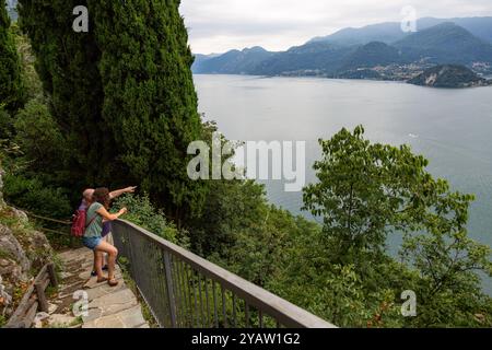 Un uomo e una donna si fermano lungo i gradini del Castello di Vezio per dare un'occhiata al Lago di Como a Perledo, in Lombardia, in Italia. Foto Stock