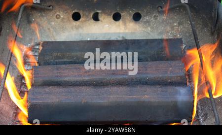 le bricchette di legno vanno a fuoco. primo piano. sfondo. Foto Stock