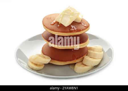 Pila di pancake con fette di banana isolate su bianco. Vista dall'alto Foto Stock