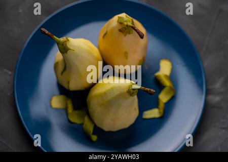 Pere sbucciate su un piatto blu. Sbucciare la pera. Foto di alta qualità Foto Stock