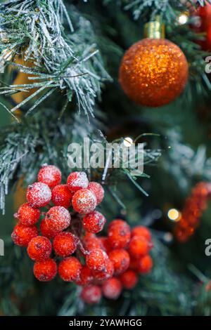 Primo piano di un bellissimo albero di Natale con bacche rosse e ornamenti Foto Stock