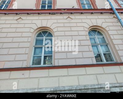 grande edificio classico a due piani con dettagli ornati, grandi finestre e una facciata blu chiaro sotto un cielo limpido. La struttura presenta elementi storici Foto Stock