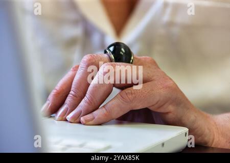 donna anziana che usa un notebook portatile, primo piano sulla mano Foto Stock