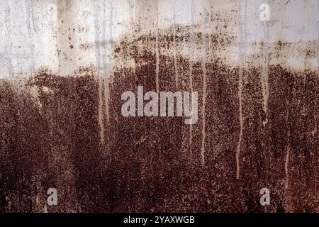 Superficie in metallo testurizzato caratterizzata da esclusivi motivi di ruggine e gocciolamenti. Immagine artistica creativa astratta che mette in evidenza una superficie arrugginita e testurizzata adornata W. Foto Stock
