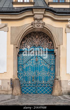Un cancello di ferro blu splendidamente ornato accentua l'ingresso di un edificio storico, mostrando elaborato artigianato e dettagli architettonici Foto Stock