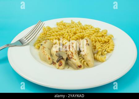 filetto di pollo con salsa di funghi e pasta, primo piano, su un piatto Foto Stock