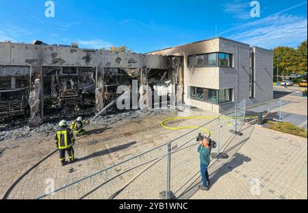 Stadtallendorf, Germania. 16 ottobre 2024. I vigili del fuoco sono impegnati a spegnere il fuoco. Il nuovo deposito di attrezzature del dipartimento dei vigili del fuoco volontario di Stadtallendorf è completamente bruciato con veicoli e attrezzature, causando milioni di danni. Crediti: Andreas Arnold/dpa/Alamy Live News Foto Stock